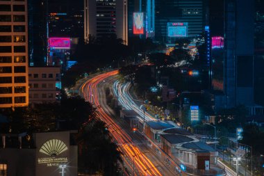 Night cityscape,and traffic light of highway in slow speed shutter motion effect and noise.Jakarta, Indonesia .January 9 2023