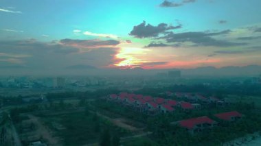 Aşağıya doğru ilerleyen bir dron günbatımını, ağaçları ve deniz kıyısını yakalıyor. Yüksek kalite 4k görüntü