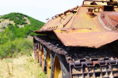 Terk edilmiş bir tankın kenarında.