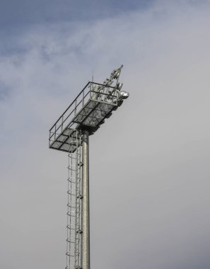 Gökyüzüne karşı bir futbol stadyumunun spot ışığı kulesi