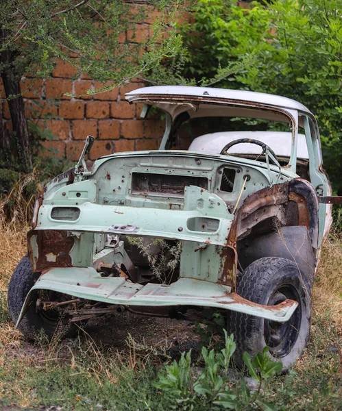 The body of an old rusty retro car without front wings, engine and doors