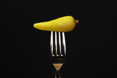 Siyah arka planda çatallı yeşil biber turşusu. yakın plan