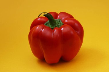 Turuncu arka planda büyük kırmızı biber. Yakın plan.