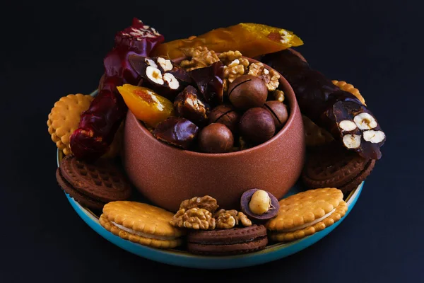 stock image Churchkhela - Georgian national delicacy and nuts with cookies around on a black background. Close-up