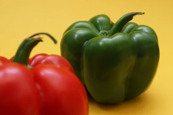 Big Green Pepper Blurred Red Pepper Orange Background Shallow Depth — Stock Photo, Image