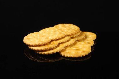 Siyah bir masada yansımalı oval krakerler. Yakın plan.