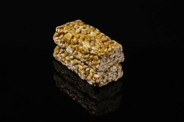 Ayçiçeği tohumlarından Kozinak siyah bir masada yansıyor. Yakın plan.