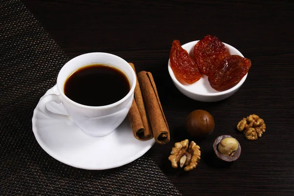 Ένα Φλιτζάνι Μαύρο Καφέ Ένα Σκούρο Τραπέζι Ξηρούς Καρπούς Κανέλα — Φωτογραφία Αρχείου