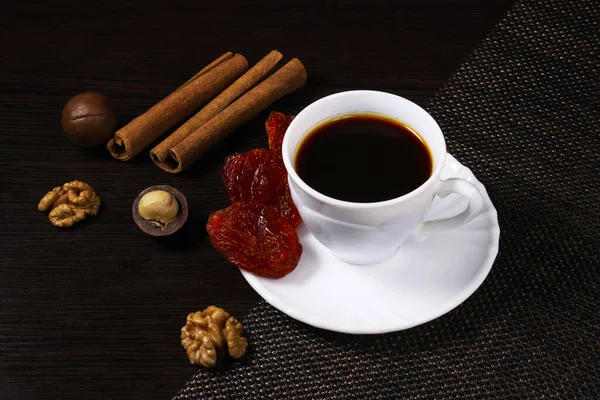 Ένα Φλιτζάνι Μαύρο Καφέ Ένα Σκούρο Τραπέζι Ξηρούς Καρπούς Κανέλα — Φωτογραφία Αρχείου