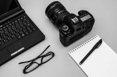 Fotoğraf makinesi, not defteri ve dizüstü bilgisayarlı foto muhabiri konsepti. Ofis araçları.