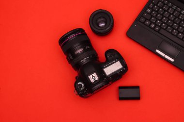 Fotomuhabirin kırmızı masasında siyah çerçeveli optik gözlük. Sığ alan derinliği