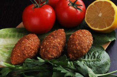 Ishli kufta. Mercimek ve bulgur bifteği. Yanında sebze olan 