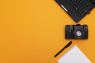 Film kamerası, not defteri ve dizüstü bilgisayarlı foto muhabiri konsepti. Ofis araçları.