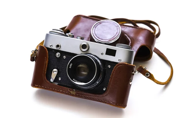 stock image Vintage film camera in a leather case on a white background. Shallow depth of field