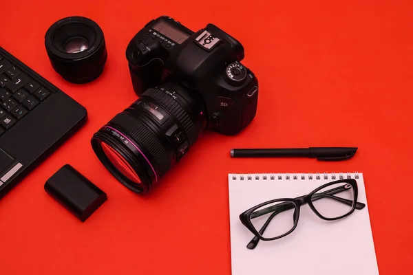 stock image Optical glasses with black frames on the red desk of a photojournalist. Shallow depth of field