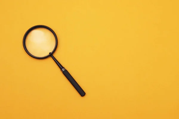 stock image Loupe or magnifying glass on an orange background. Shallow depth of field