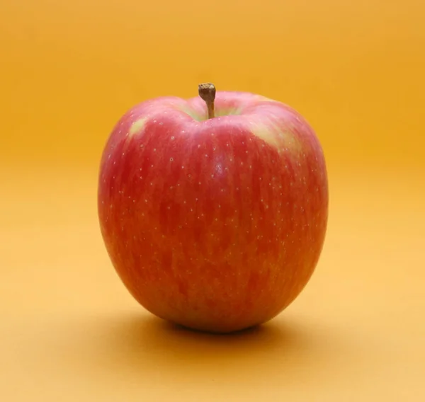 Červené Jablko Oranžovém Pozadí Mělká Hloubka Pole — Stock fotografie