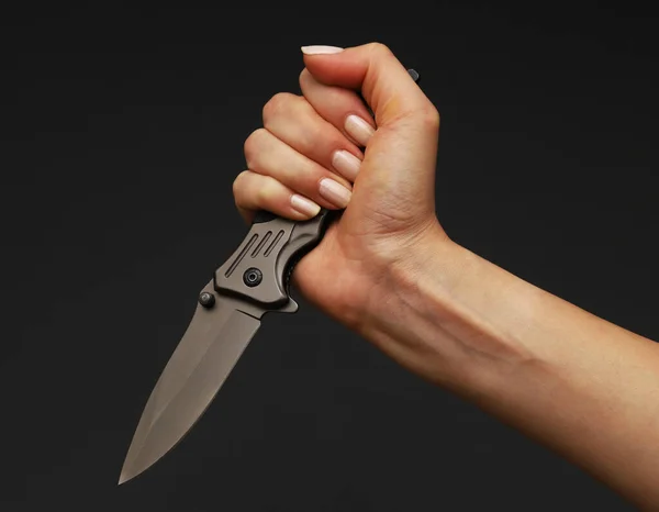 Folding knife in the hands of a woman. Close-up