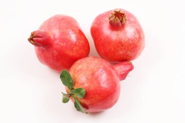 Beyaz arka planda kırmızı, olgun bir nar. Sığ alan derinliği