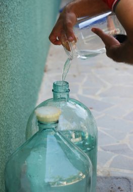 Evdeki büyük bir sürahide kaçak votka dolduruyorum.