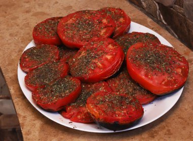 Üzerine tuz ve baharat serpiştirilmiş ızgara domates. Sığ alan derinliği