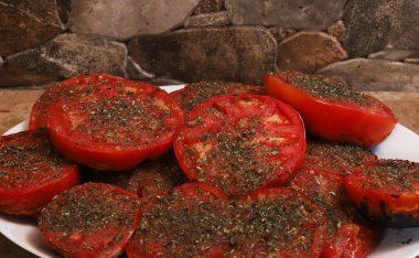 Üzerine tuz ve baharat serpiştirilmiş ızgara domates. Sığ alan derinliği