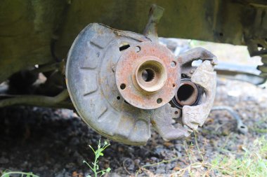 Terk edilmiş bir arabanın şasesinde paslı bir merkez.