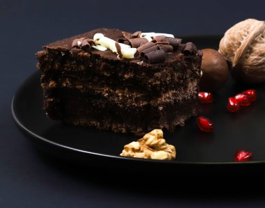 Koyu ışığın altında tabakta çikolatalı pasta. Sığ alan derinliği