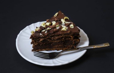 Koyu ışığın altında tabakta çikolatalı pasta. Sığ alan derinliği