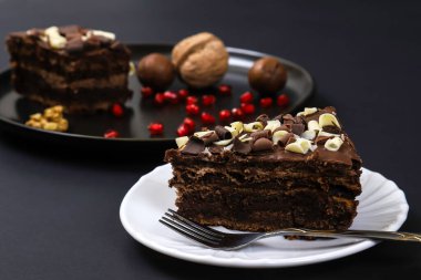 Koyu ışığın altında tabakta çikolatalı pasta. Sığ alan derinliği