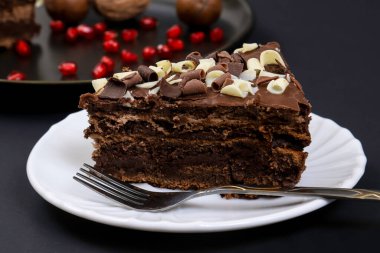 Koyu ışığın altında tabakta çikolatalı pasta. Sığ alan derinliği