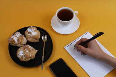 Ev yapımı krema ve portakal masasında bir fincan çay. Yukarıdan görüntüle