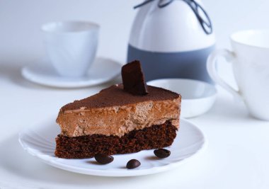 Parlak ışıkta bir tabağın üzerindeki çikolatalı tatlı pastasının bir parçası. Sığ alan derinliği