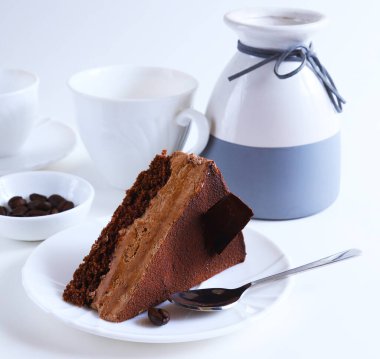 Parlak ışıkta bir tabağın üzerindeki çikolatalı tatlı pastasının bir parçası. Sığ alan derinliği