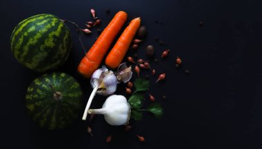 Siyah arka planda sebzeler. Havuç, sarımsak, ot, cüce ampuller, karpuz. Sığ alan derinliği