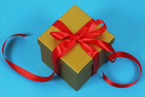 Κουτί Δώρου Από Χρυσό Χαρτί Κραφτ Κόκκινη Κορδέλα Μπλε Φόντο — Φωτογραφία Αρχείου