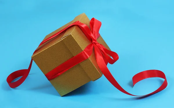 Κουτί Δώρου Από Χρυσό Χαρτί Κραφτ Κόκκινη Κορδέλα Μπλε Φόντο — Φωτογραφία Αρχείου