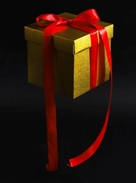Hangend Lucht Gouden Kraftpapier Geschenkdoos Met Rood Lint Zwarte Achtergrond — Stockfoto