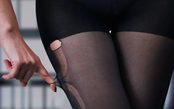 Geçmişi bulanık siyah külotlu çorap giymiş bir kızın seksi kalçaları. Kadın vücudunun ayrıntıları.