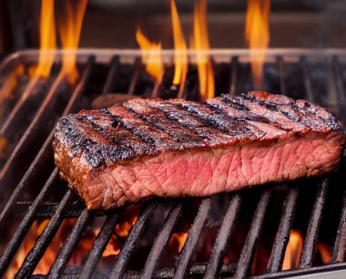 Arkaplanda mermer biftek ya da ızgara biftek. Sığ alan derinliği