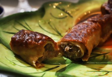 Thin pancakes stuffed with minced meat and fried onions in a bowl. Shallow depth of field