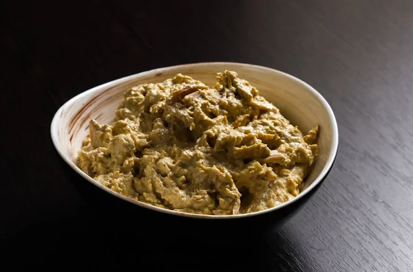 Satsivi, a Georgian poultry dish in a walnut sauce. Close-up of a Satsivi dish in a plate on a light background