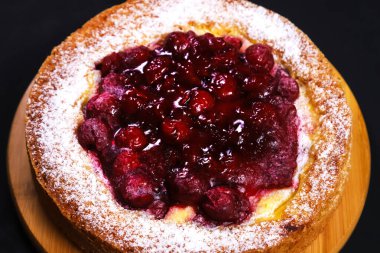 Ahşap bir tahta üzerinde ahududu reçeli ve pudra ile turta. Yakın plan.