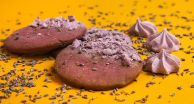 Lavantalı kurabiyeler ve kenarlarında lavanta çiçekleri olan küçük şekerlemeler. Yakın plan.