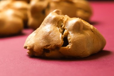 Burgundy arka planında kremalı cevizli kahve kurabiyeleri. Yakın plan.