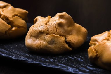 Koyu arkaplanda kremalı fındıklı kahve bisküvileri. Yakın plan.