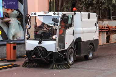 Şehir sokaklarını süpürmek için aygıtı olan bir araba.