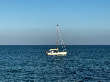 Ufuktaki denizde küçük bir yelkenli gemi.