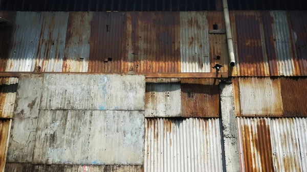 旧建筑上布满生锈的波纹锡墙和滚动式门 — 图库照片