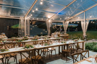 Düğün resepsiyonu akşam yemeği masası ve güzel bir çiçek süslemesi..